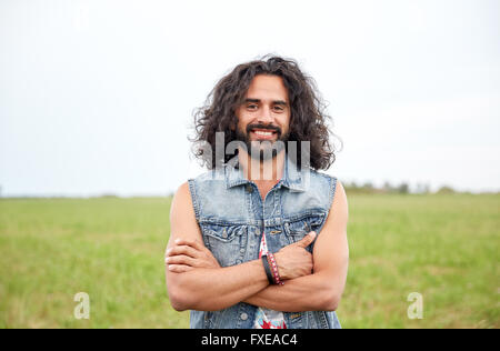 smiling young hippie man on green field Stock Photo