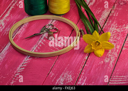 Tools for needlework and sewing thread with two colors in the same tone with Narcissus flower Stock Photo