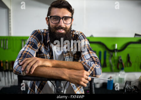 Bike mechanic leaning on a bike Stock Photo