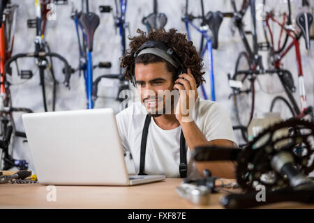 Worker using phone and laptop Stock Photo