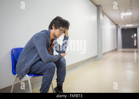 Thoughtful student sitting on chair Stock Photo