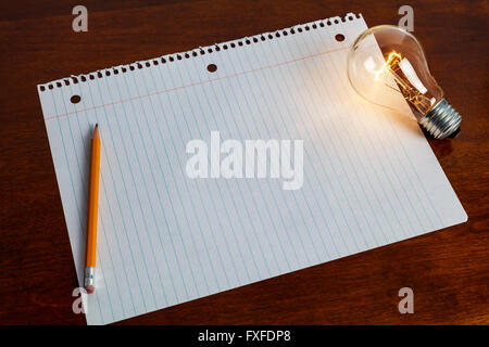 notebook paper and light bulb, business education concept. Stock Photo