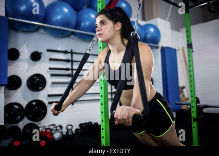 Woman doing crossfit push ups with trx fitness straps Stock Photo