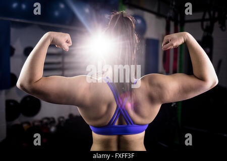 Rear view of woman flexing muscles Stock Photo