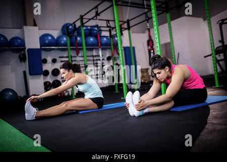 Two women stretching in the gym Stock Photo