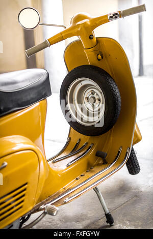Yellow scooter parked in the garage. Stock Photo
