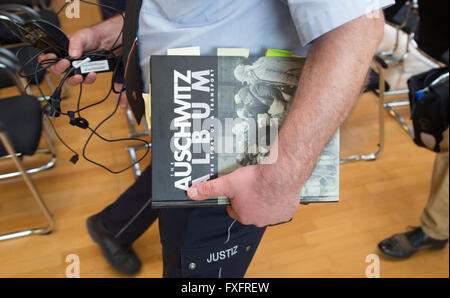 Detmold, Germany. 15th Apr, 2016. A judicial officer carries an edition of the book 'Auschwitz Album' after a trial hearing in Detmold, Germany, 15 April 2016. It belongs to the expert witness. The defendant Reinhold Hanning, a 94-year-old World War II SS guard is facing a charge of being an accessory to at least 170,000 murders at Auschwitz concentration camp. Prosecutors state that he was a member of the SS 'Totenkopf' (Death's Head) Division and that he was stationed at the Nazi regime's death camp between early 1943 and June 1944. © dpa/Alamy Live News Stock Photo
