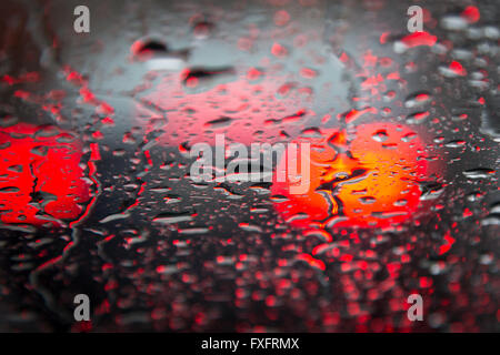 Detmold, Germany. 15th Apr, 2016. Rain drops on a car window after heavy rain in Detmold, Germany, 15 April 2016. The break lights of a car can be seen through the window. PHOTO: FRISO GENTSCH/dpa/Alamy Live News Stock Photo