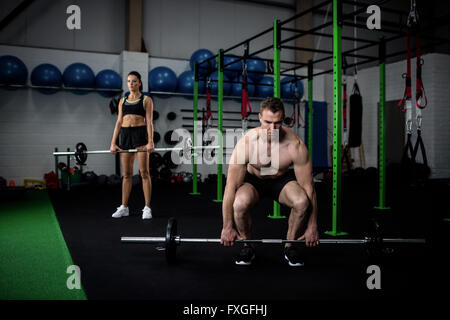 Man and woman lifting barbell Stock Photo