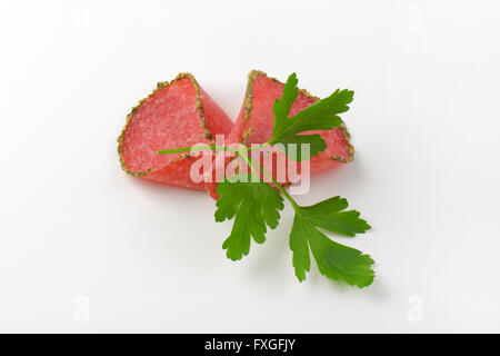 slices of green pepper coated salami on white background Stock Photo