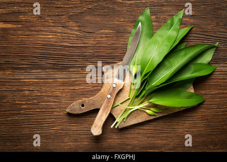 Wild garlic leafs on wooden background overhead shoot Stock Photo