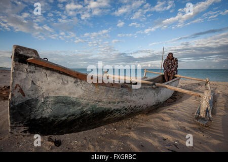 Mozambique, a fisherman is taking a rest on the boat at the beach at sunrise time. Stock Photo