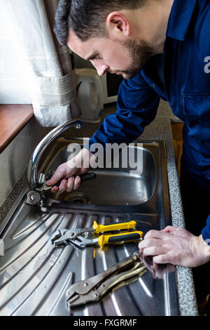 Plumber fixing the sink with wrench Stock Photo