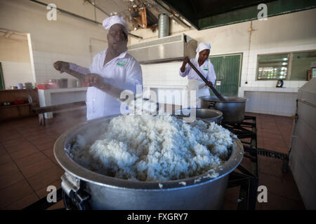 Mozambique,man and woman are cooking rice, traditional cousin. Stock Photo