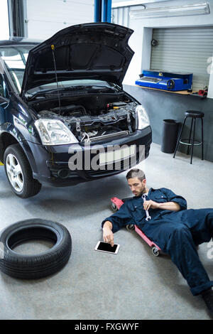 Mechanic using digital tablet while repairing a car Stock Photo