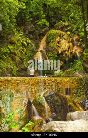 Tourists bathing at Caldeira Velha (Old Cauldron), a pool fed by a hot waterfall on the island of Sao Miguel, Azores Stock Photo