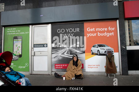 London. Waterloo. A young man begging in front of an advert with the words 'Go your way'. Stock Photo