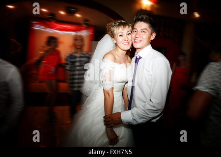 Bride and groom dancing motion on dance floor during wedding reception in  restaurant. Stock Photo