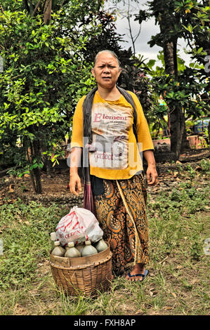 A Javaese woman seller of jamu, traditional Indonesian medicine, which she makes herself from herbs. Stock Photo