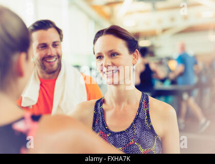 Smiling friends talking in gym Stock Photo