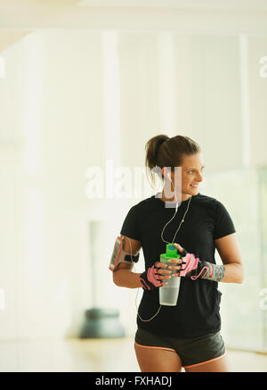 Smiling woman taking a break drinking water in gym studio Stock Photo