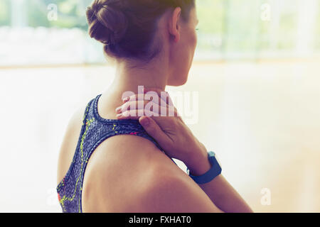 Woman rubbing neck at gym Stock Photo