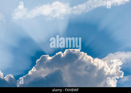 Amazing sun rays coming out from behind the clouds, blue sky Stock Photo