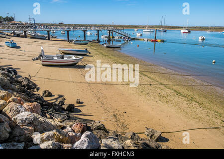 A boat has been pulled out of the water onto the beach. Stock Photo