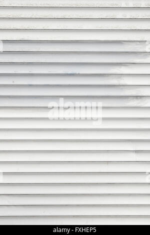 White dirty horizontal metal window roller shutter blinds background with gray paint strokes Stock Photo