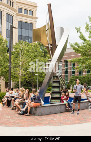 People sit and eat lunch in Boyd Plaza around Robert Carroll's fountain sculpture Apollo Cascade at the Columbia Art Museum during the weekly Farmers Market on Assembly Street in Columbia, SC. Stock Photo