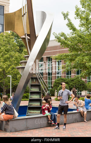 People sit and eat lunch in Boyd Plaza around Robert Carroll's fountain sculpture Apollo Cascade at the Columbia Art Museum during the weekly Farmers Market on Assembly Street in Columbia, SC. Stock Photo