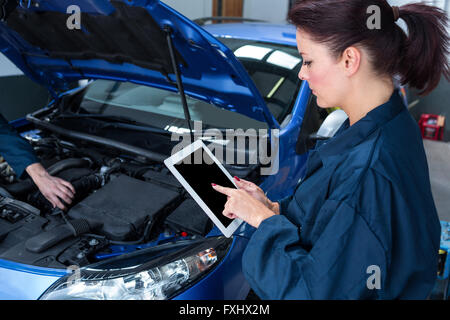 Female mechanic using digital tablet Stock Photo