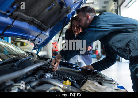 Mechanic showing customer the problem with car Stock Photo