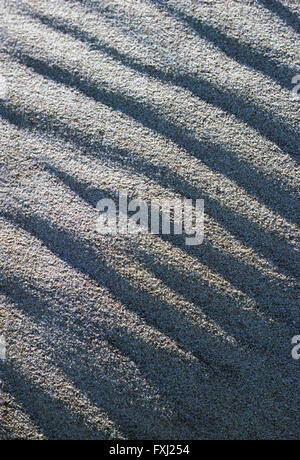 Detailed close-up of sunlit patterns in beach sand Stock Photo