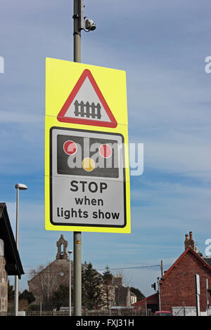 A railway level crossing STOP when lights show sign Stock Photo