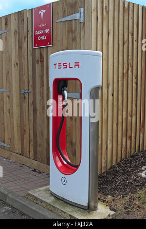 Tesla car charging point at Gretna motorway services in a parking bay for Tesla cars only Stock Photo