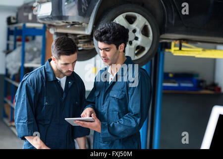 Mechanics interact using digital tablet Stock Photo