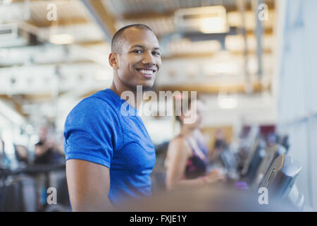 Portrait smiling man on treadmill at gym Stock Photo