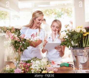Florists with digital tablet arranging bouquet in flower shop Stock Photo
