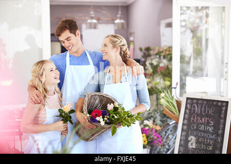 Florists smiling and hugging in flower shop Stock Photo