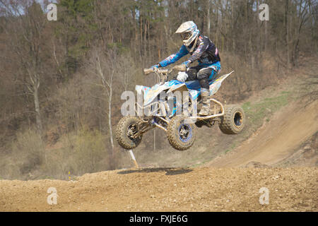 Racer is jumping on quad motorbike Stock Photo