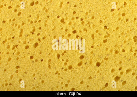 Yellow washing sponge with holes and bubbles used for cleaning background Stock Photo