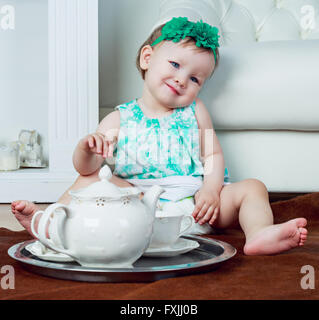 cute one year old baby drinking tea at home Stock Photo