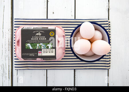 Free Range Duck Eggs with bowl and Carton on a blue and white napkin over a rustic white table Stock Photo