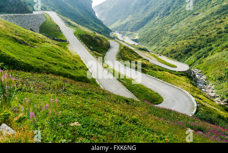 The old road Tremola to Gotthard Pass, Passo del St. Gottardo, winding up a green mountain slope, Airolo, Tessin, Switzerland Stock Photo