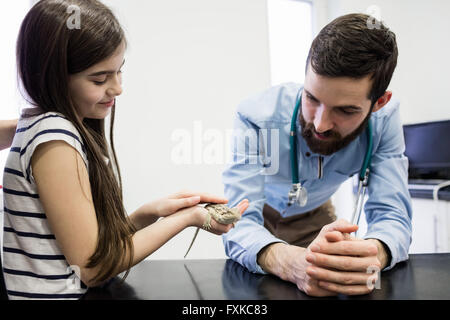 Vet looking at lizard in girls hand Stock Photo