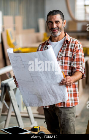 Carpenter holding a blueprint Stock Photo