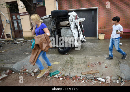 Dolores, Uruguay. 16th Apr, 2016. People walk in front of an overturned car after a tornado in Dolores, Uruguay, on April 16, 2016. A tornado thrashed the city of Dolores, western Uruguay, on Friday, leaving four people dead and others seriously injured, the country's emergency services said. Credit:  Nicolas Celaya/Xinhua/Alamy Live News Stock Photo