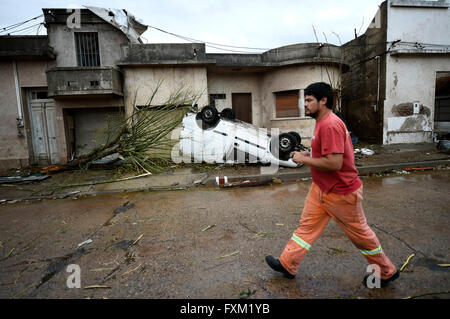 Dolores, Uruguay. 16th Apr, 2016. A man walks in front of an overturned car after a tornado in Dolores, Uruguay, on April 16, 2016. A tornado thrashed the city of Dolores, western Uruguay, on Friday, leaving four people dead and others seriously injured, the country's emergency services said. Credit:  Nicolas Celaya/Xinhua/Alamy Live News Stock Photo