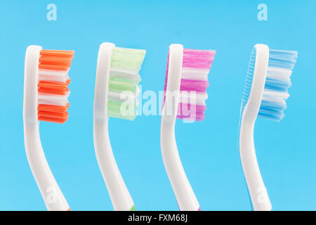 Colourful toothbrushes isolated on blue. Stock Photo